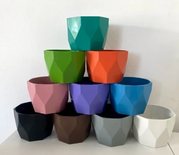 Diversos potes coloridos feitos de PP Reciclado empilhados um sobre o outro.
